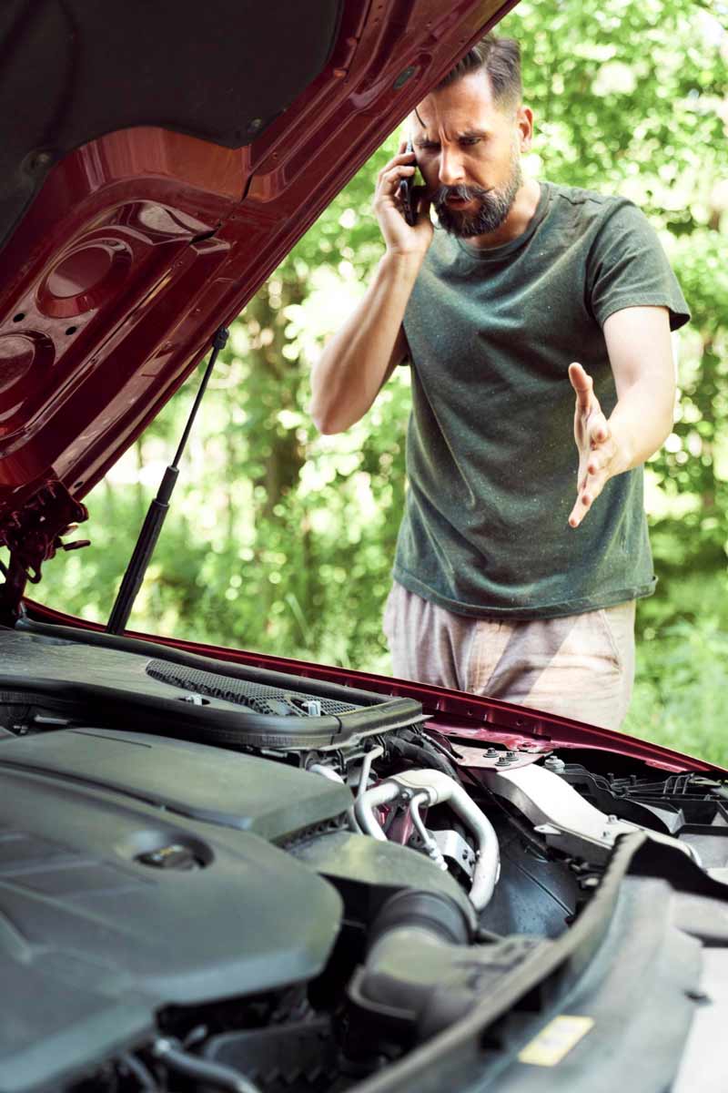 Junger Mann prüft Getriebeschaden bei Schrottauto Ankauf Elmshorn